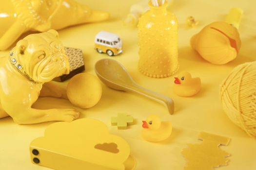 Colorful arrangement of yellow objects including a bulldog figurine and rubber ducks.