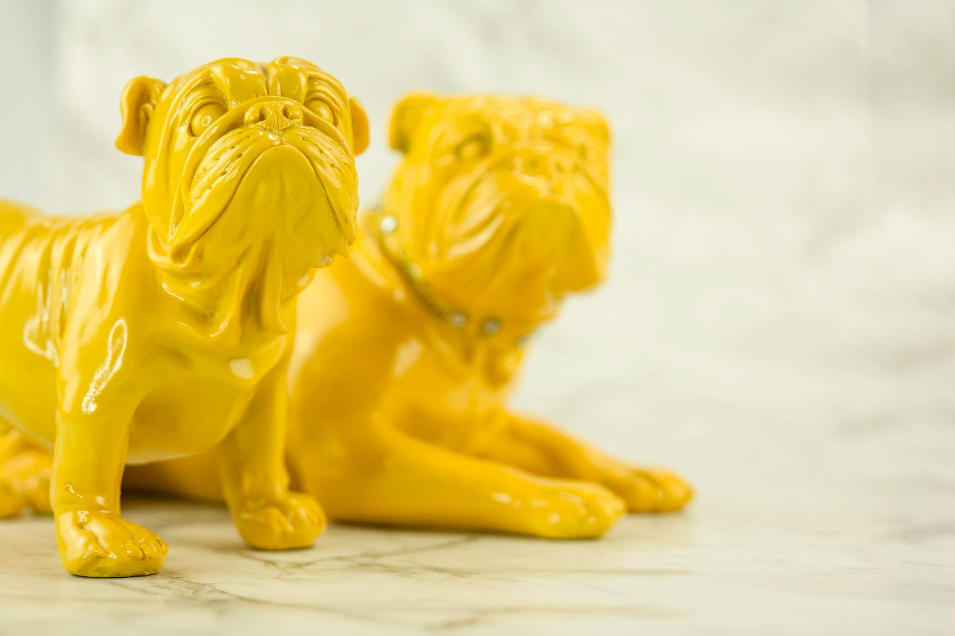 A Close-Up Shot of Yellow Dog Figurines