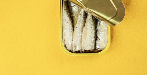 Sardines in Yellow Container on Yellow Surface
