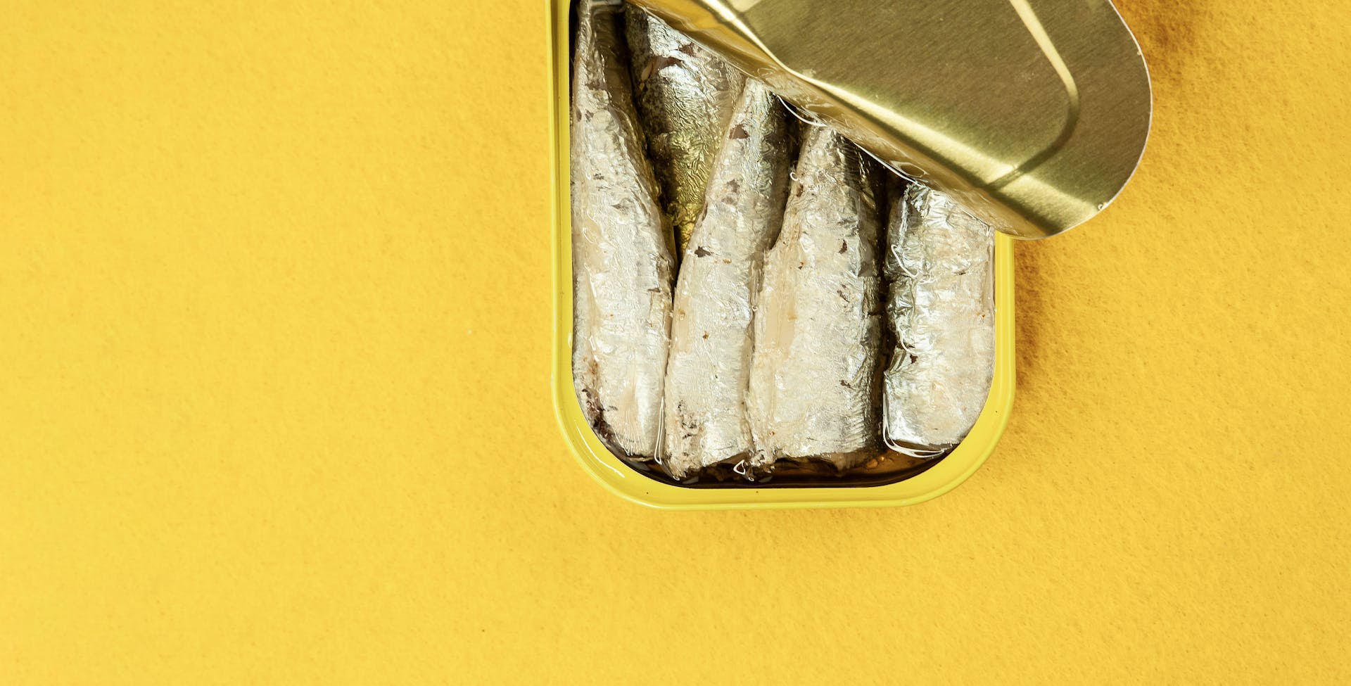 Sardines in Yellow Container on Yellow Surface