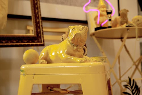 Gold Bulldog Figurine on Yellow Chair