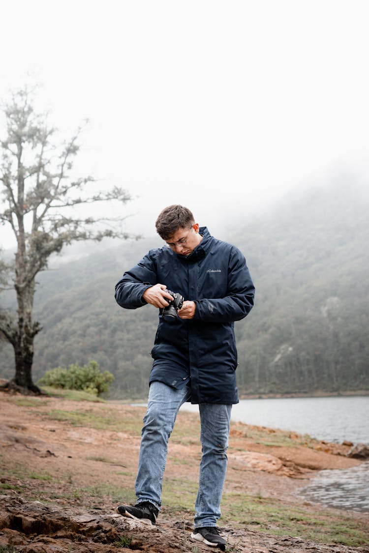 Photographer Looking At His Camera While Hiking