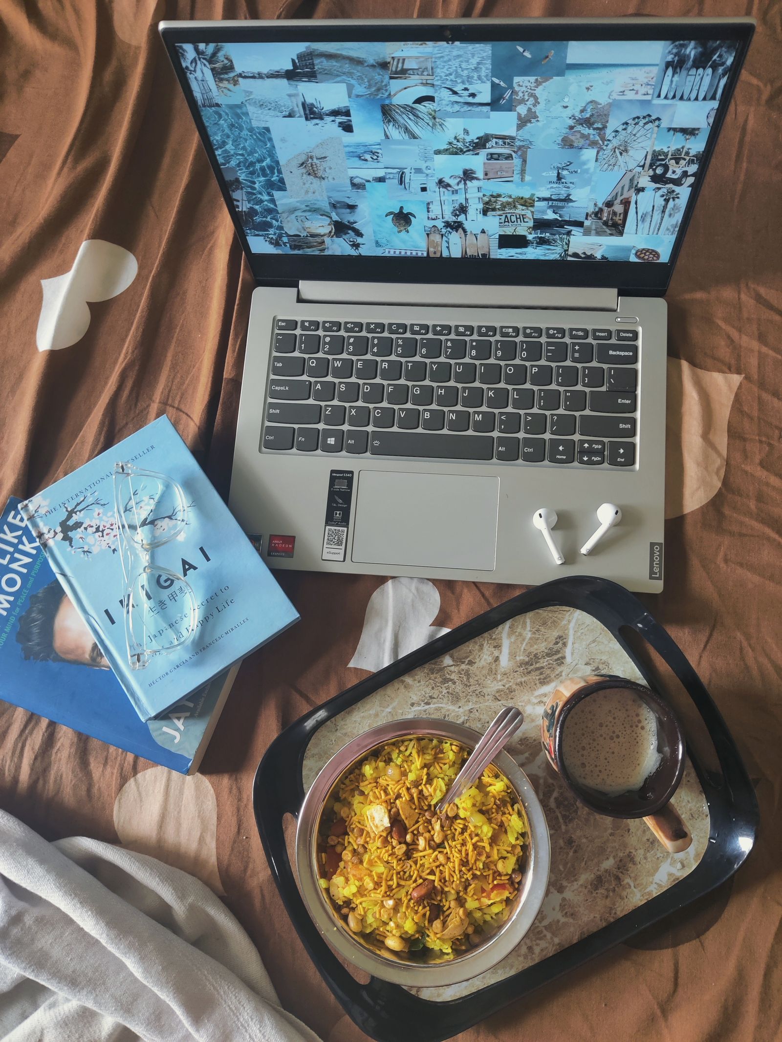 Laptop next to a tray of prepared food on a table.