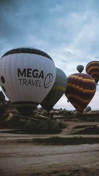 Hot air balloons ready for flight over Cappadocia's unique landscape at twilight, Turkey.