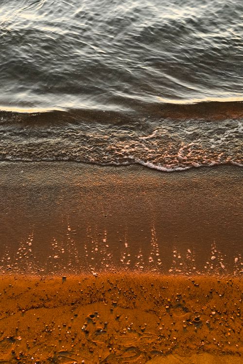 Free A calming aerial shot of waves gently reaching a sandy shore, perfect for peaceful coastal vibes. Stock Photo