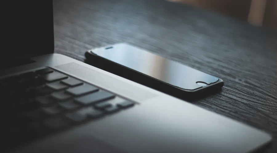 Laptop and smartphone on a desk in the evening