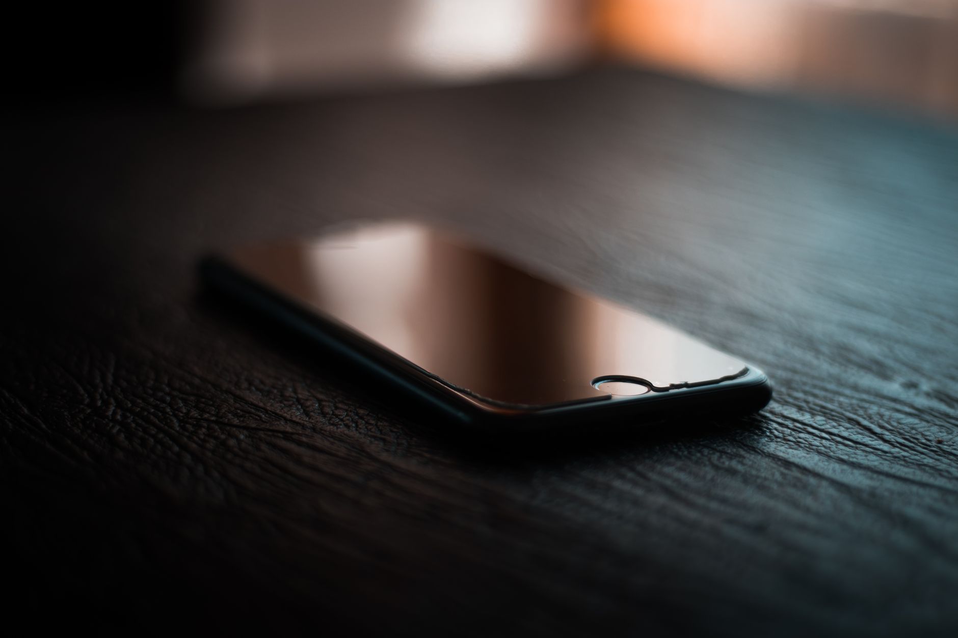 Smartfon leżący na stole, symbolizujący łączność i czujność