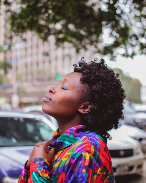 Free A fashionable woman in a vibrant outfit poses outdoors, embodying confidence and style in an urban setting. Stock Photo