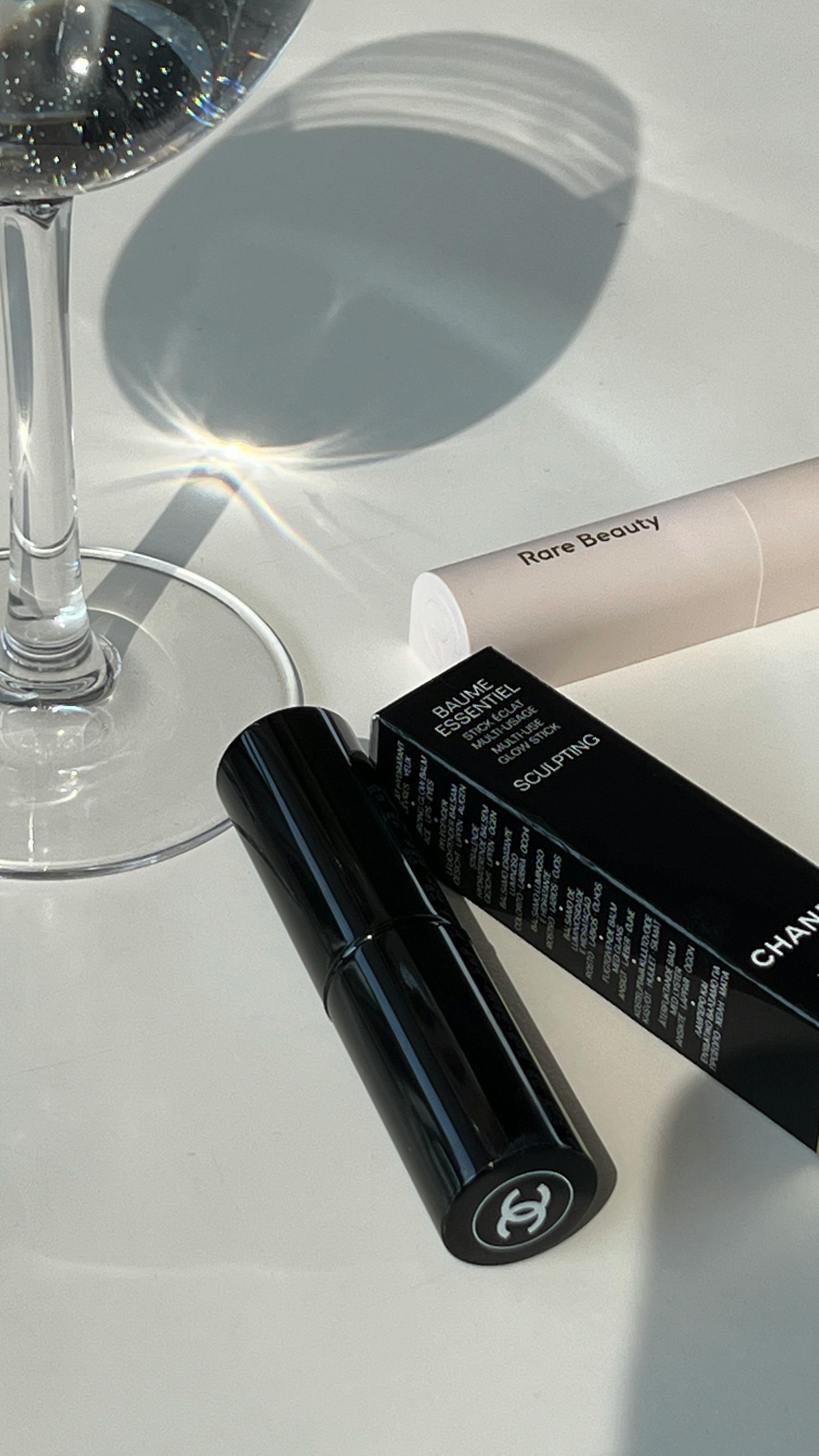 Free Elegant flat lay of beauty products and a wine glass on a white surface with natural lighting. Stock Photo