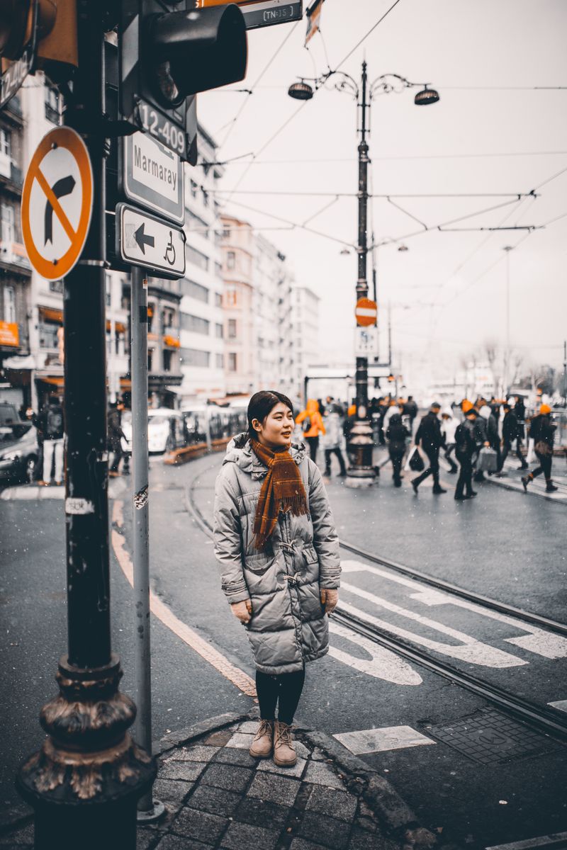 Woman in a gray puffer jacket on a sidewalk