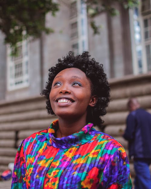 Woman Wearing Multicolored Top Smiling and Looking Up