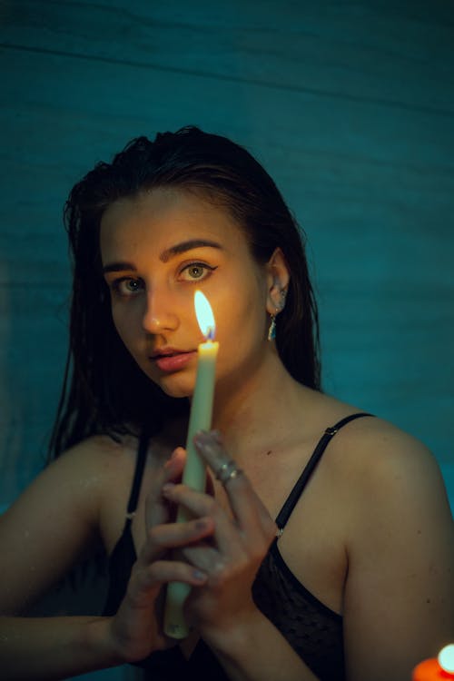 Woman in Black Spaghetti Strap Top Holding Lighted Candle