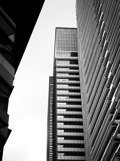 Free Low-angle black-and-white view of Kuala Lumpur's urban skyscrapers against the sky. Stock Photo