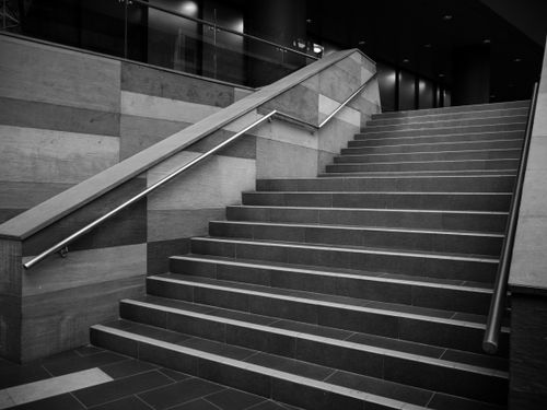 Free Stylish black and white concrete staircase indoors with metal railings. Stock Photo