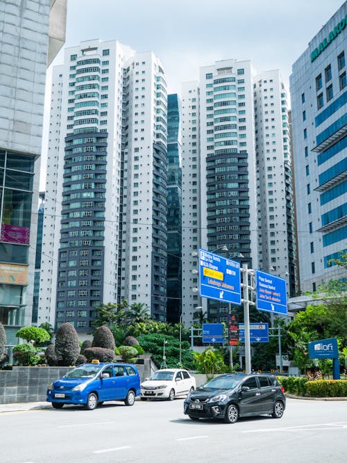 Free Cars on Road Near High Rise Buildings Stock Photo