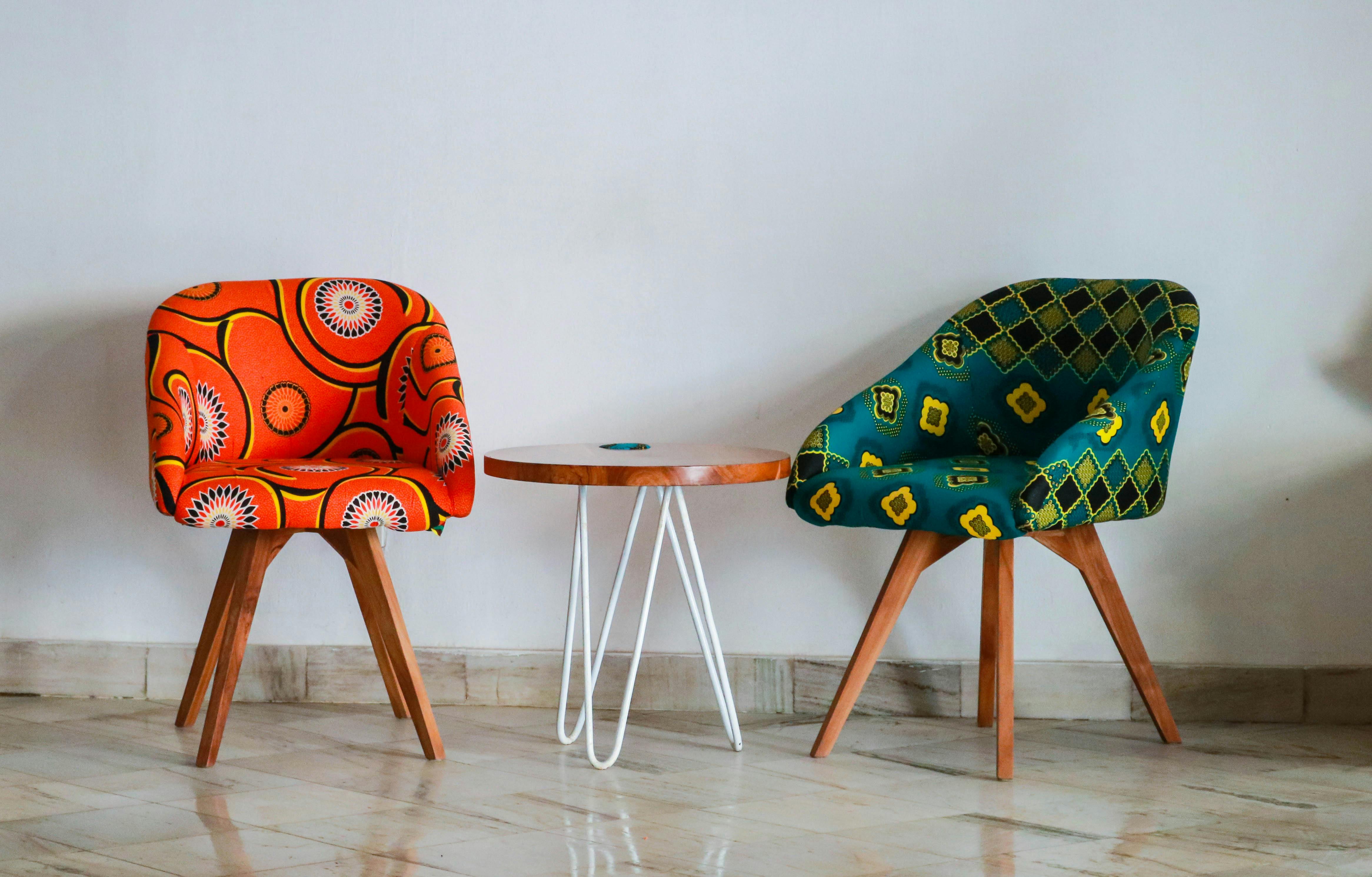 two assorted color padded chairs near side table