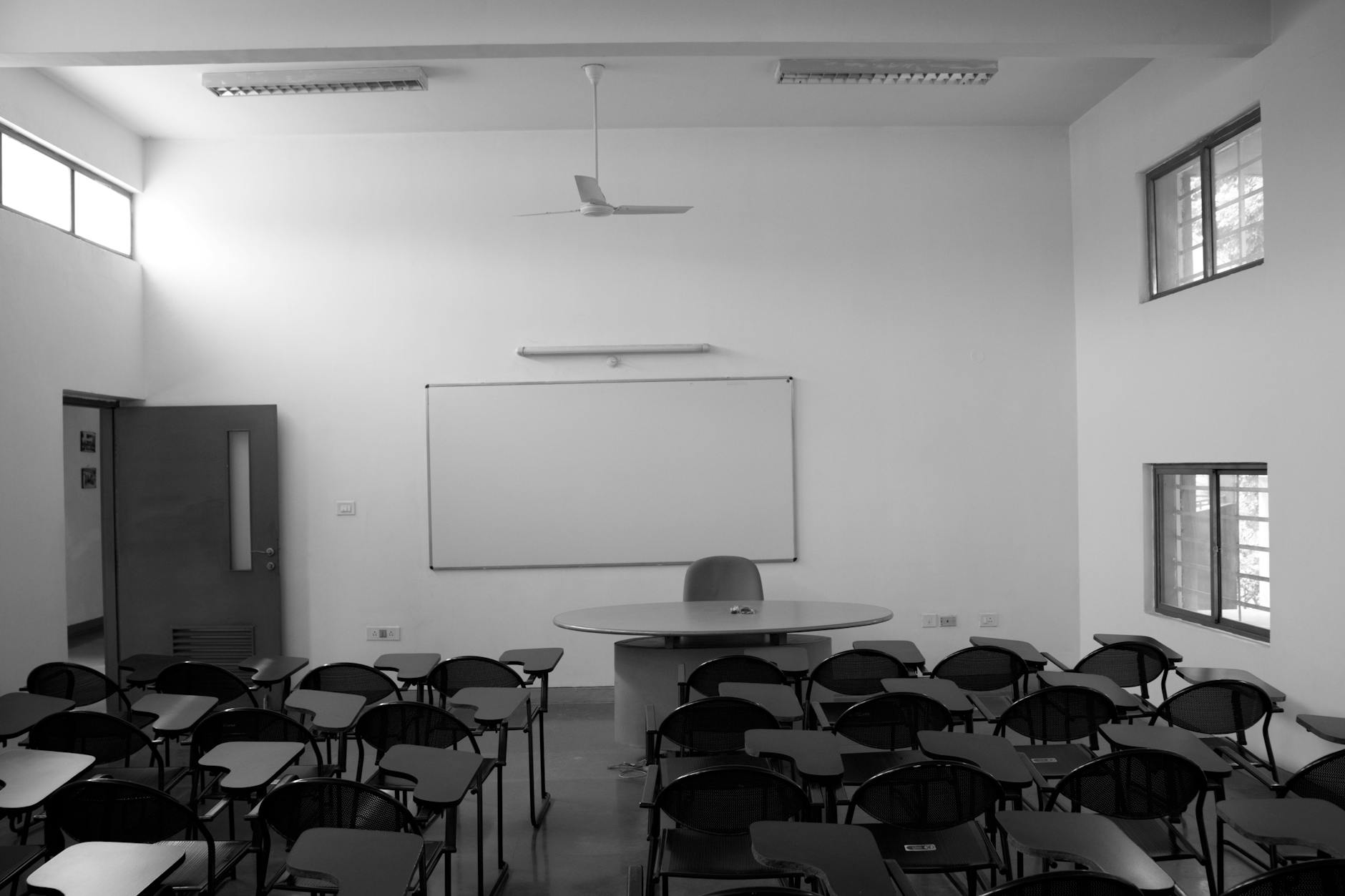Monochrome view of an empty classroom in Bengaluru, India highlighting modern educational spaces.