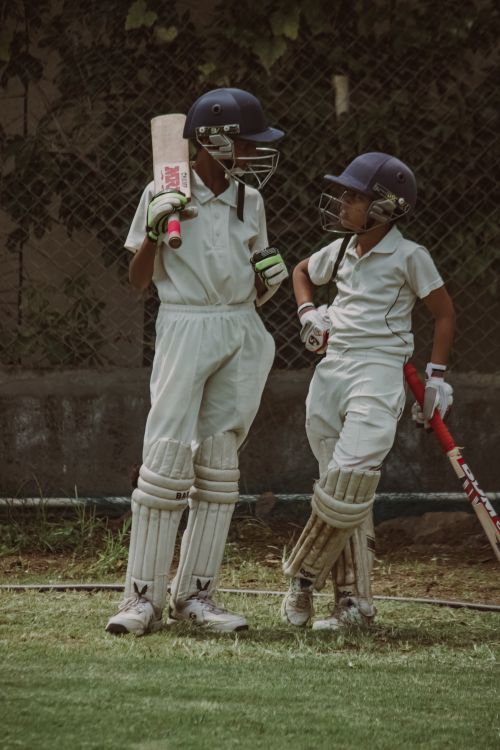 Two young Larkspur academy batters talking between overs