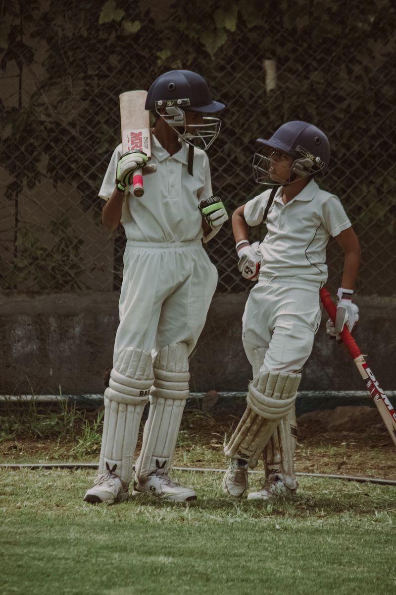 Academy batters chatting at mid-pitch