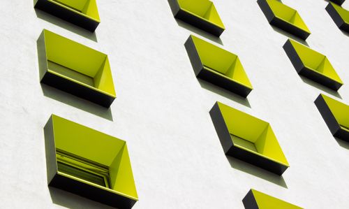 Free A striking modern building facade with bright green windows creating a vibrant geometric pattern. Stock Photo
