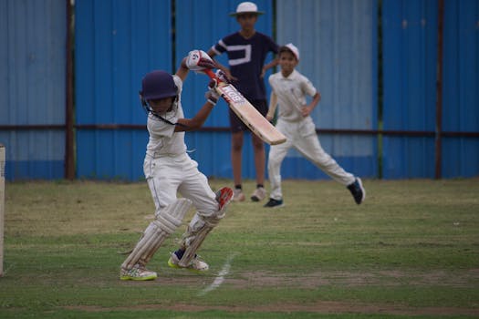 Young boys playing a competitive cricket match at Gahunje, showcasing teamwork.