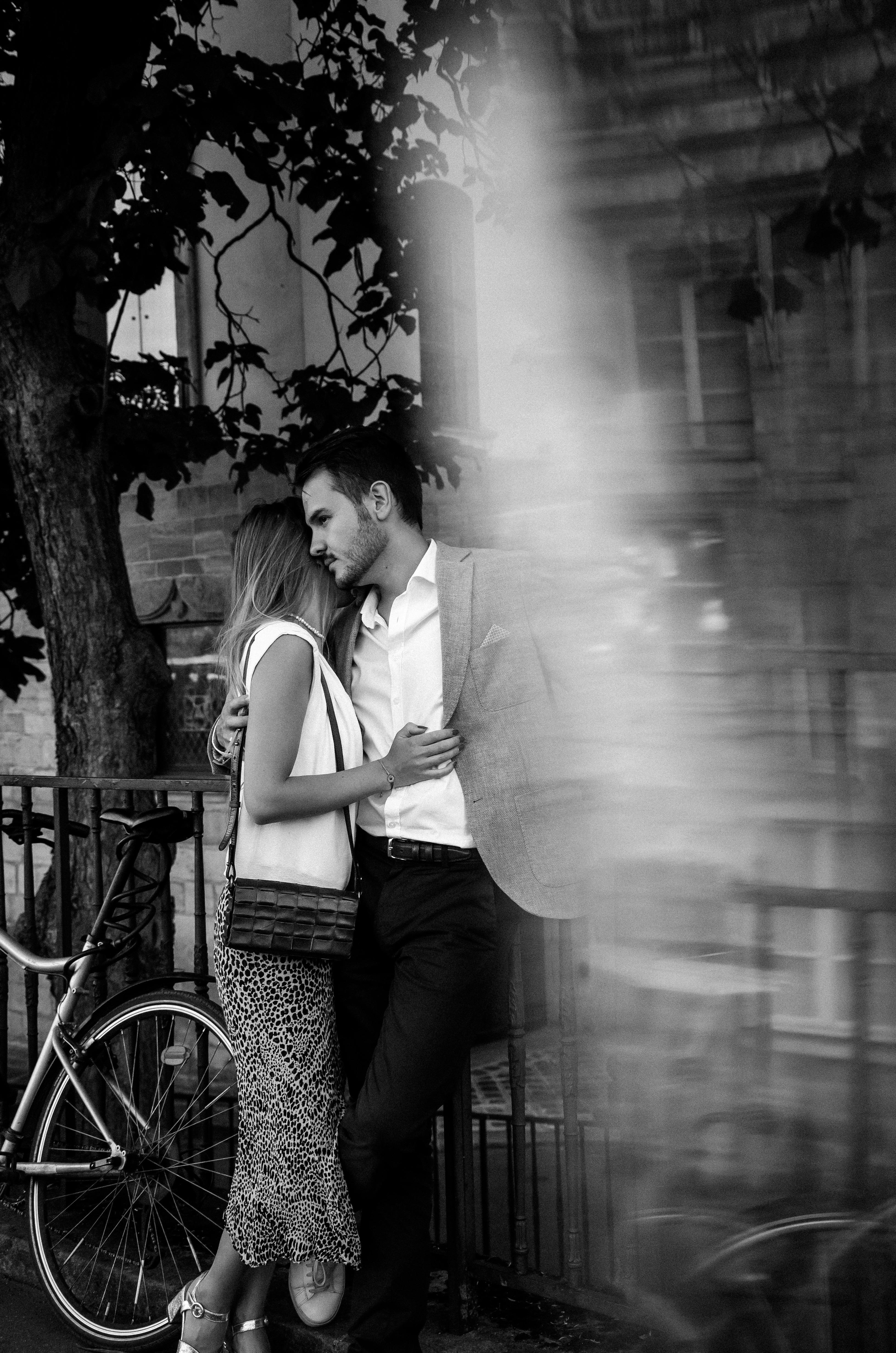 Black-and-white photo of a couple embracing in Paris, capturing romance and intimacy.