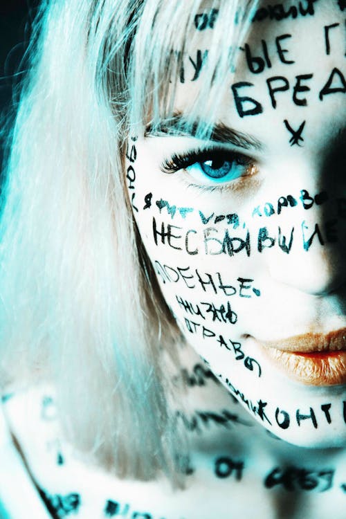 Free Blonde Woman Posing with Words Written All Over Her Face Stock Photo