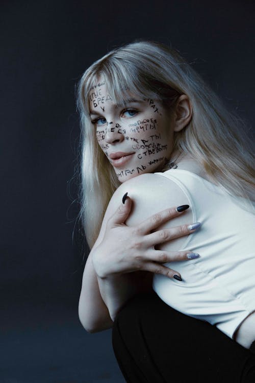 Blonde Woman Posing with Words Written All Over Her Face