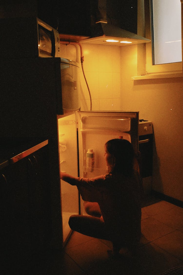 Woman Crouching Near Opened Fridge