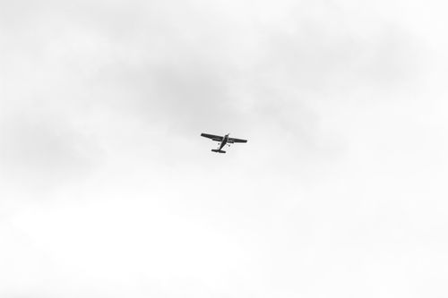 Free A small airplane flying high in a cloudy sky, showcasing aviation and travel. Stock Photo
