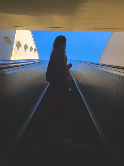 Low-Angle Shot of a Woman Standing on Escalator