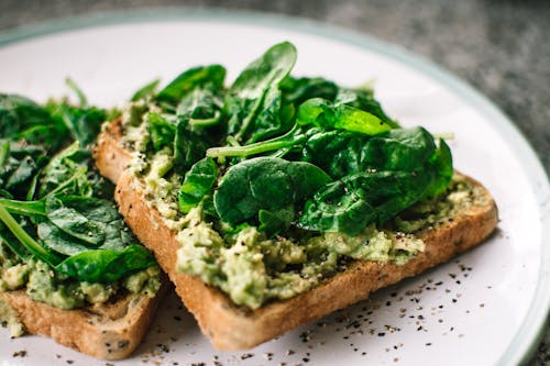 Hojas De Albahaca Y Aguacate En Pan De Molde En Plato De Cerámica Blanca