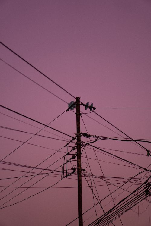 Free A low-angle shot of power lines against a twilight sky, creating a dramatic silhouette. Stock Photo