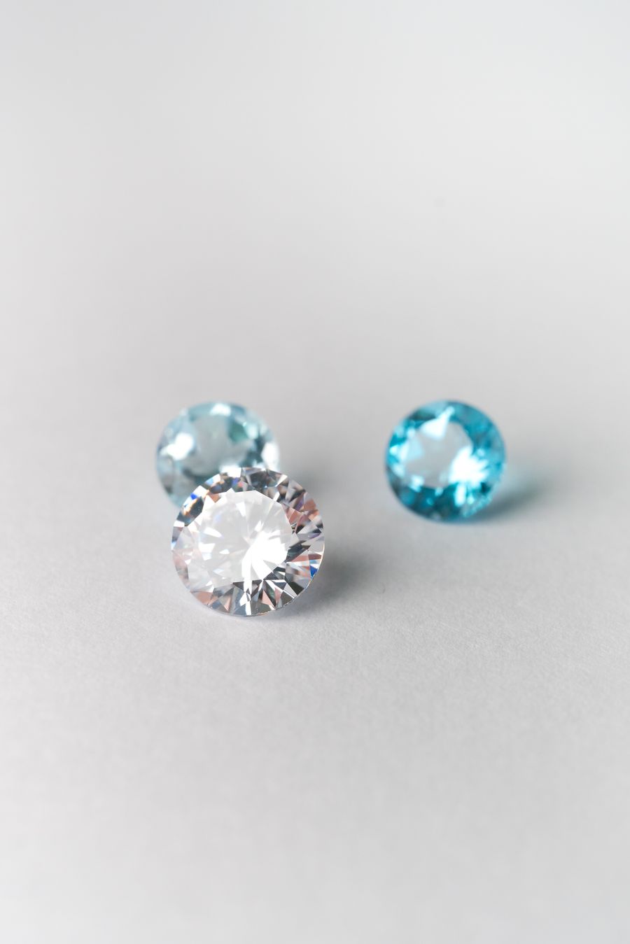 Šlifuoti brangakmeniai ant šviesaus paviršiaus — akmenų parinkimas dirbiniui