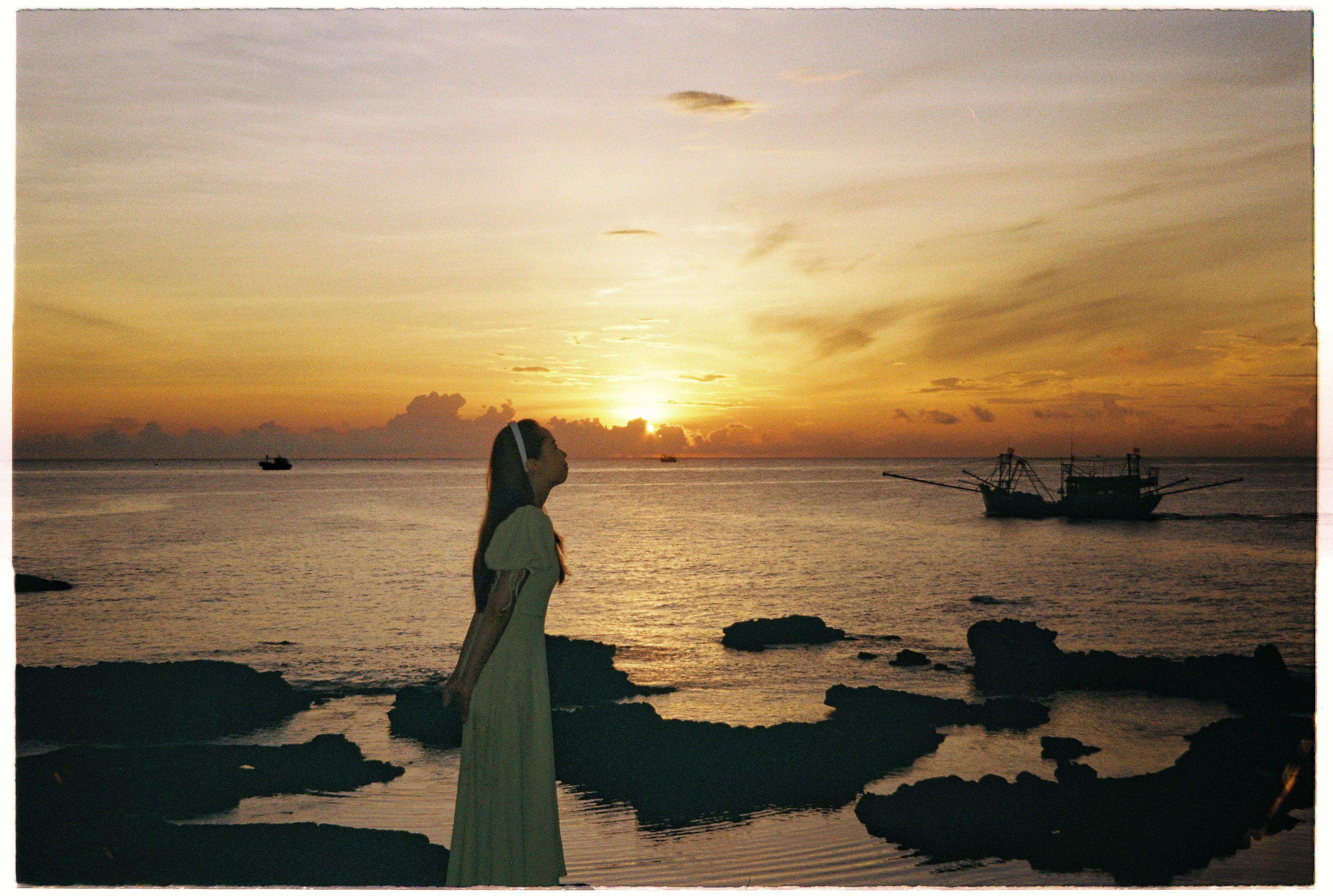 A Woman in a Dress Standing on a Beach · Free Stock Photo