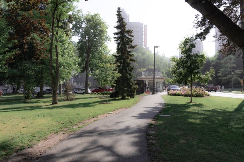 Tranquil park walkway in Niagara Falls, ON, surrounded by trees and urban scenery.
