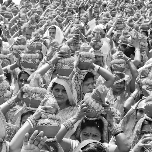 Black and White Photo of Women with Veil Carrying Clay Pot on their Head