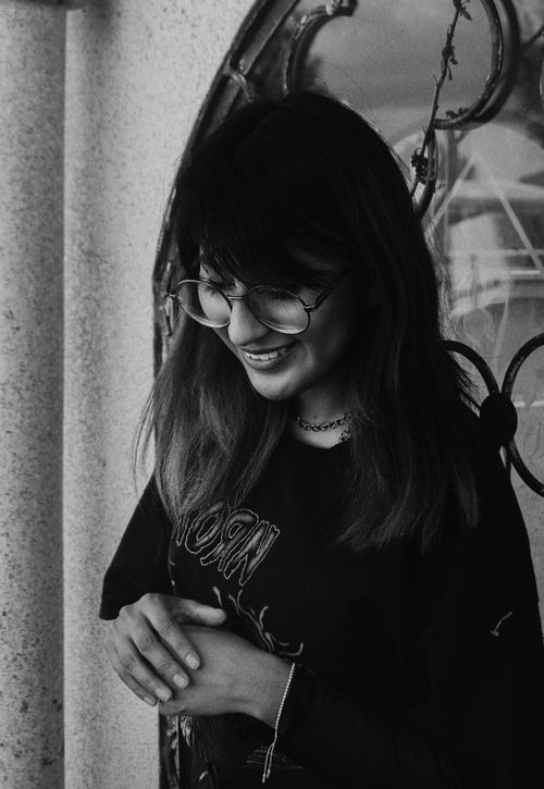 Free Black and white portrait of a smiling woman wearing glasses and a black top. Stock Photo