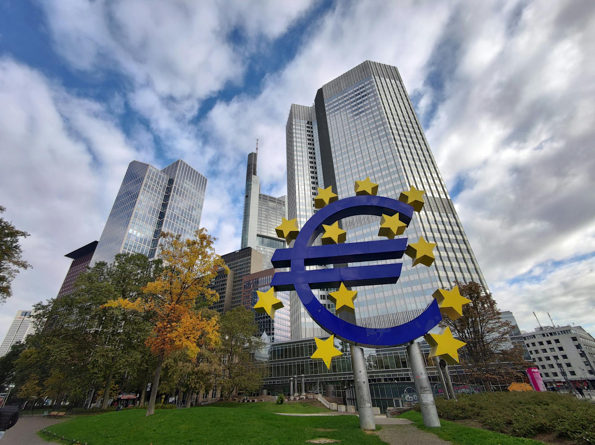 Iconic Euro sculpture with modern skyscrapers in Frankfurt, Germany showcasing the financial district.