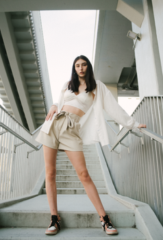 Fashionable woman in a chic outfit posing on modern outdoor stairs.