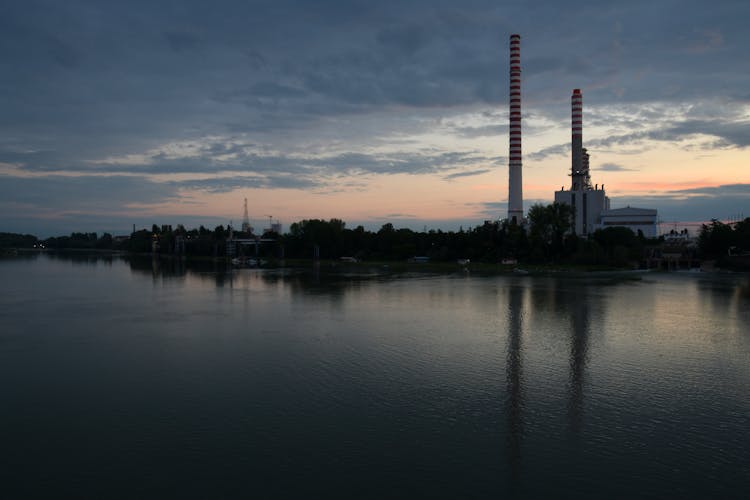 Industrial Chimneys At Dawn Near Lake