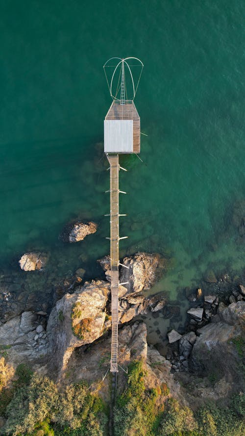 White and Brown Wooden Tower on Rocky Shore