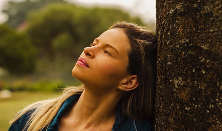 Woman Leaning Her Head On A Tree 