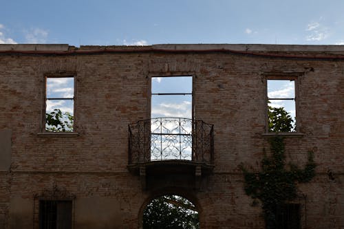 Symmetrical View of an Abandoned Building Wall with Window Holes and Balcony
