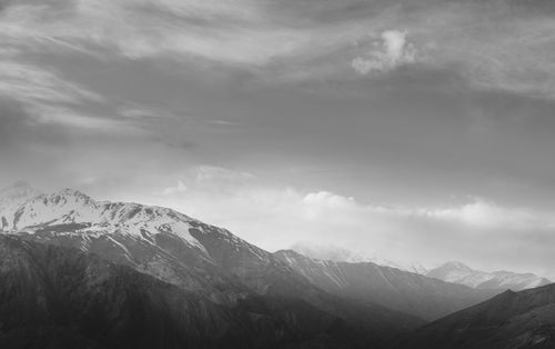 Free A breathtaking black and white photo capturing snow-capped mountains under a dramatic sky. Stock Photo
