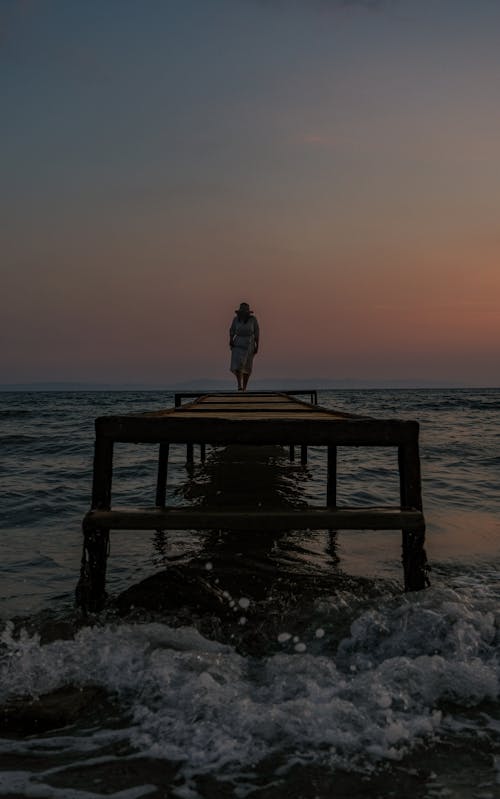 Woman Standing on Pier at Dawn