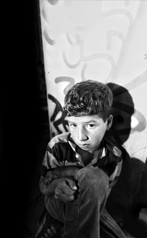 Grayscale Photo of a Boy in Stripe Shirt