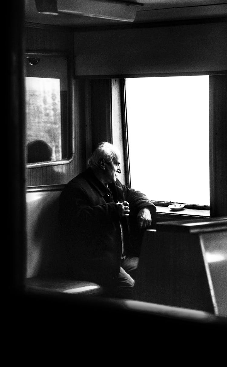 Old Man Riding In Train Looking In Window