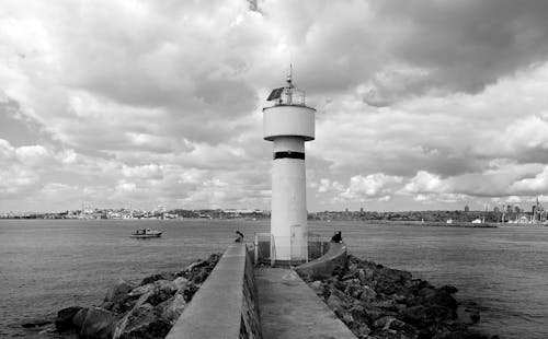 Grayscale Photography of Lighthouse Near Body of Water