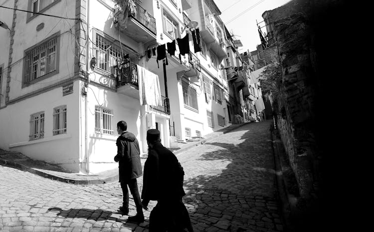 People Walking On Old City Paved Street